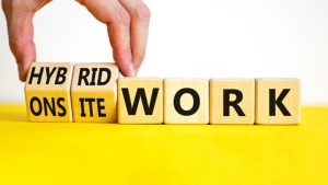 Hybrid or onsite work symbol. Businessman turns cubes and changes words 'onsite work' to 'hybrid work'. Beautiful white background. Business, hybrid or onsite working concept, copy space.